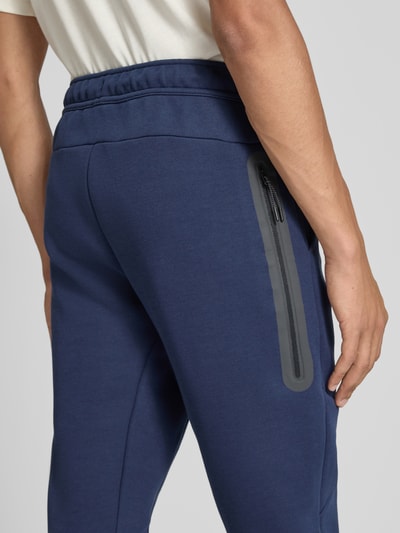 Männermodel trägt Slim Fit Sweathose aus katoenmix von Nike in donkerblauw, gladde stof, detailopname heupzone, Heren Sweathose van Nike