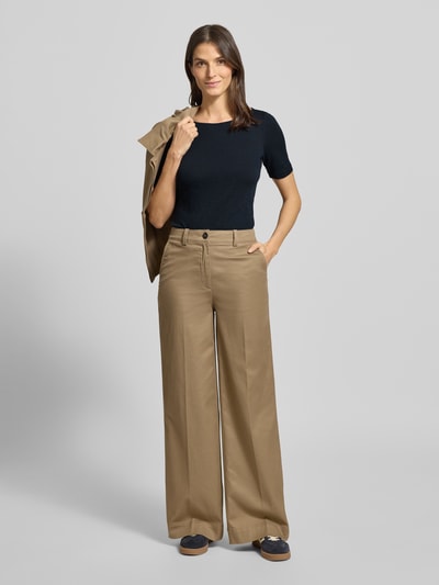 Modelka nosi T-shirt aus Slub Jersey von Marc O'Polo, damski t-shirt z czarnej bawełny, krój slim fit, okrągły dekolt, nadruk z logo, długość tyłu 64 cm, widok całej sylwetki z przodu.