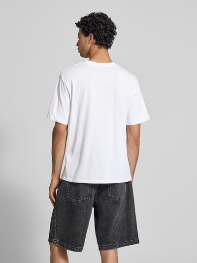 Männermodel trägt Relaxed Fit T-Shirt mit Statement-Print Modell 'Photo' von Jack & Jones aus Reine Baumwolle in Weiß, Rückenansicht Ganzkörperansicht Rückansicht.