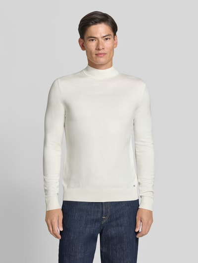 Männermodel trägt Rollkragenpullover mit Viskose-Anteil von MARKUP in creme, gerader Schnitt, gerippte Abschlüsse, Ganzkörperansicht von vorne.