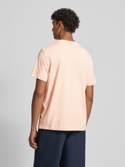 Männermodel trägt T-Shirt mit Logo-Stitching Modell 'Priamo' von JOOP! Collection in Hellrosa, Baumwolle, Rückansicht, Ganzkörperansicht.
