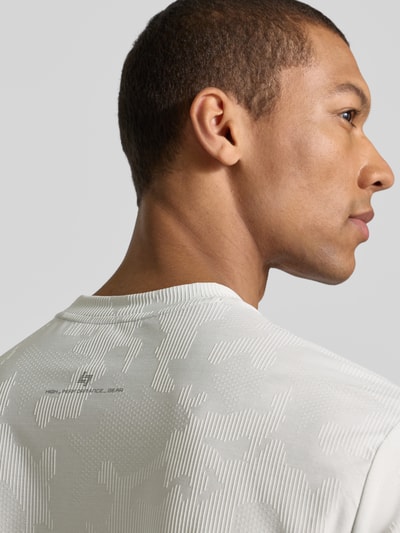 Mannelijk model draagt T-shirt met ronde hals en label-detail van EA7 Emporio Armani, regular fit, materiaal-mix met stretch, detailopname schouder rugaanzicht.