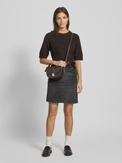 Kobiece modelka nosi Ausgestellter Mini-Rock mit Baumwoll-Anteil od s.Oliver RED LABEL, czarny strukturalny sztruks, krój regular fit, 5 kieszeni, pasek, mini długość, widok całej sylwetki z przodu.