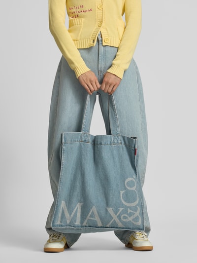 Frauenmodel trägt Barrel Fit Jeans mit Denim-Tasche Modell 'MCOCANTORE' von MAX&Co., hellblauer Denim, weite Passform, Damen Barrel Jeans, Nahaufnahme Unterkörper.
