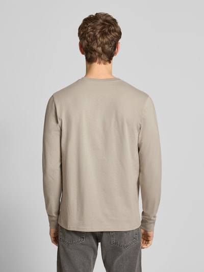 Männermodel trägt Longsleeve mit Brusttasche und Label-Detail von Carhartt Work In Progress, Baumwolle, Regular Fit, Rückansicht Ganzkörperansicht.