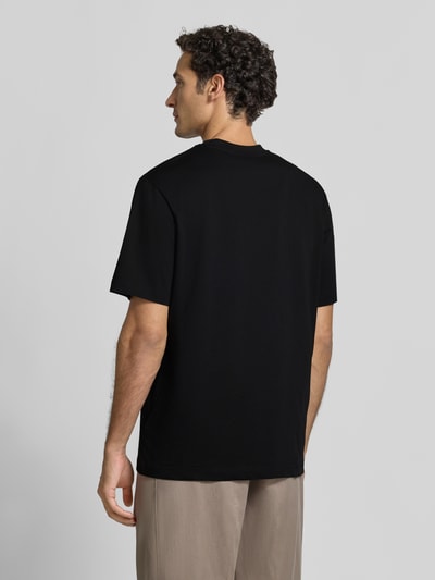 Männermodel trägt Relaxed Fit T-Shirt aus reiner Baumwolle von Antony Morato, Schwarz, glatte Textur, Logo-Detail, Ganzkörperansicht Rückansicht. Rückenlänge bei Größe M: 69 cm, Rundhalsausschnitt.