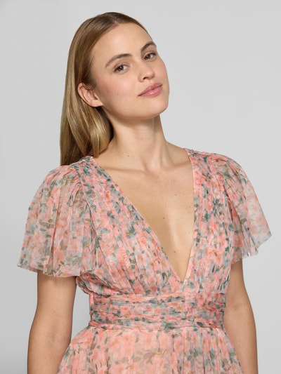 Frauenmodel trägt Cocktailkleid im Stufen-Look mit Taillenband von LACE & BEADS aus Mesh mit V-Ausschnitt, Drapierungen und floraler Musterung, taillierte Passform, Nahaufnahme Oberkörper.