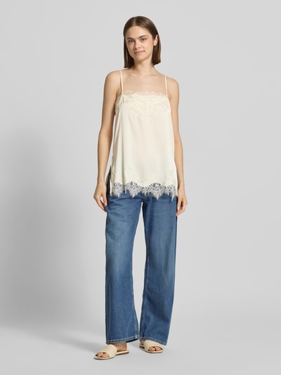 Frauenmodel trägt Spitzentop mit verstellbaren Spaghettiträgern von Gina Tricot in Creme, Spitzen-Details, Straight Fit, Ganzkörperansicht von vorne.