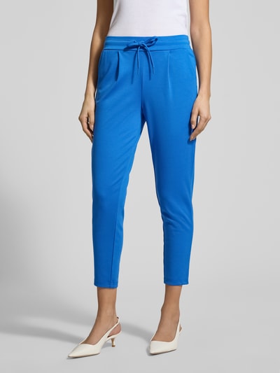 Frauenmodel trägt Slim Fit Stoffhose mit Viskose-Anteil Modell 'Kate' von ICHI, leuchtend blau, Eingrifftaschen, elastischer Bund mit Tunnelzug, Bundfalten, Elastischer-Material-Mix, Detailaufnahme Beine.