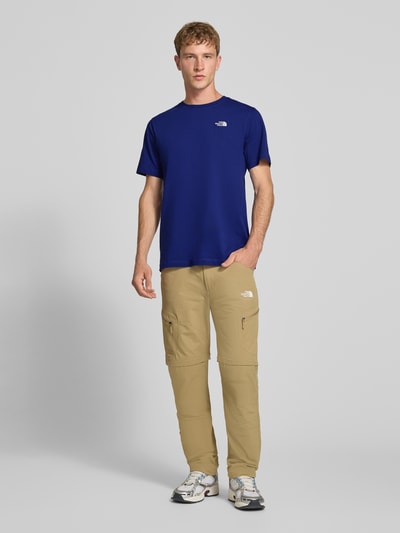 Männermodel trägt Regular fit t-shirt met ronde hals Model 'EVOLUTION' van The North Face in blauw, Heren, labelstitching, ruglengte bij maat M: 72 cm, geheel aanzicht van voren