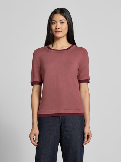 Vrouwenmodel draagt Slim Fit gebreid shirt uit viscosemix van Christian Berg Woman in effen oudroze met 2-in-1-look, ronde hals, halflange mouwen, ruglengte maat S 57 cm, mouwlengte 29 cm, Ganzkörperansicht van voren.