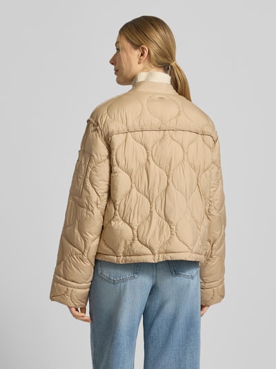 Frauenmodel trägt beige Steppjacke mit Zweiwege-Reißverschluss Modell 'IMANE' von Beaumont Amsterdam, Relaxed Fit, Ganzkörperansicht Rückansicht.