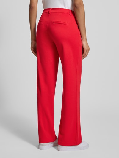 Frauenmodel trägt Wide Fit Stoffhose mit Viskose-Anteil Modell 'Nanni' von FREE/QUENT in kräftigem Rot, elastischer Material-Mix, Gesäßtaschen, Knopf- und Reißverschluss, Bundweite 40 cm, Innenbeinlänge 79 cm, Ganzkörperansicht Rückansicht.