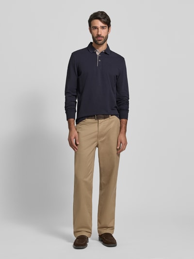 Męski model nosi Regular Fit Koszulkę polo z kołnierzykiem w kontrastowym kolorze i wyhaftowanym logo od Bugatti, bawełna, granatowy, bluzka z długim rękawem, listwa guzikowa, długość tyłu 71 cm dla rozmiaru M, widok całej sylwetki od przodu.