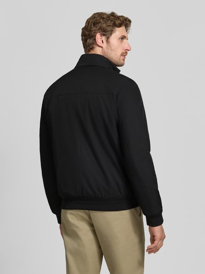 Männermodel trägt Blouson mit Zweiwege-Reißverschluss und Eingrifftaschen von Geox in Schwarz, glatte Textur, Ganzkörperansicht Rückansicht. Regular Fit, Stehkragen, Rückenlänge 67 cm, Schulterbreite 46 cm, Brustweite 53 cm, Ärmellänge 68 cm.