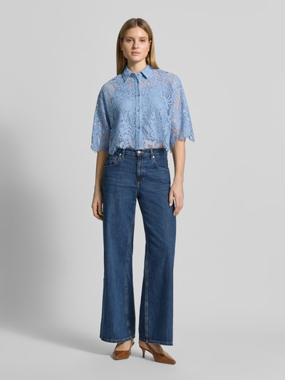 Frauenmodel trägt Bluse mit Spitze und Hemdblusenkragen von MICHAEL Michael Kors aus Material-Mix mit Baumwoll-Anteil, Semitransparent, verkürzte Passform, Knopfleiste, 3/4-Arm, Farbe Hellblau, Rückenlänge bei Größe S 49 cm, Ärmellänge 32 cm, Ganzkörperansicht von vorne.