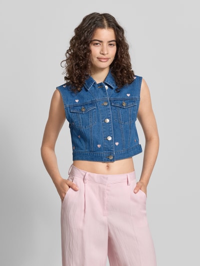 Frauenmodel trägt Regular Fit Jeansweste mit Motiv-Print Modell 'VEGA' von Only in Denim-Optik mit Umlegekragen, Knopfleiste, Label-Applikation, Brusttaschen, reine Baumwolle, mittleres Blau, Strukturmix, Ganzkörperansicht von vorne.