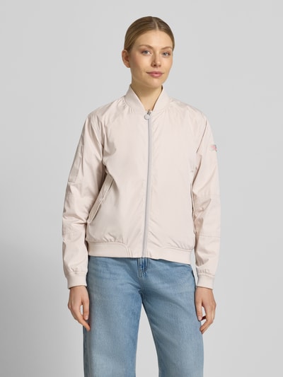 Frauenmodel trägt Regular Fit Bomberjacke mit Stehkragen Modell 'Brooklyn' von Frieda & Freddies in hellem Beige mit Reißverschluss, Eingrifftaschen und elastischen Abschlüssen, kombiniert zu hellblauer Jeans, Ganzkörperansicht von vorne. Rückenlänge bei Größe 36: 59 cm, Schulterbreite: 44 cm, Brustweite: 52 cm, Ärmellänge: 51 cm.