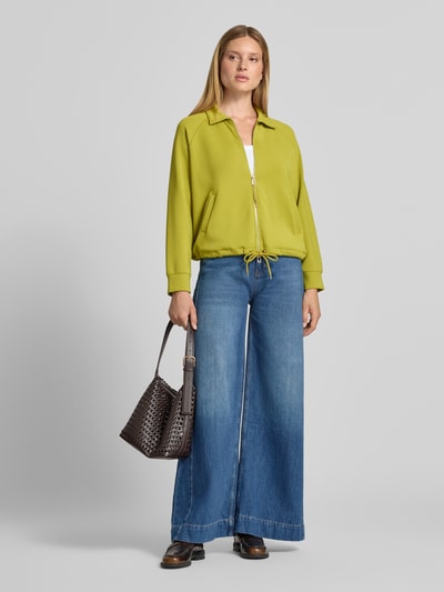 Vrouwenmodel draagt limegroene sweatjack met tweewegritssluiting Model 'Taimi' van JOOP!, materiaalmix met modal, relaxed fit, platte kraag, steekzakken en tunnelkoord, Ganzkörperansicht von voren.