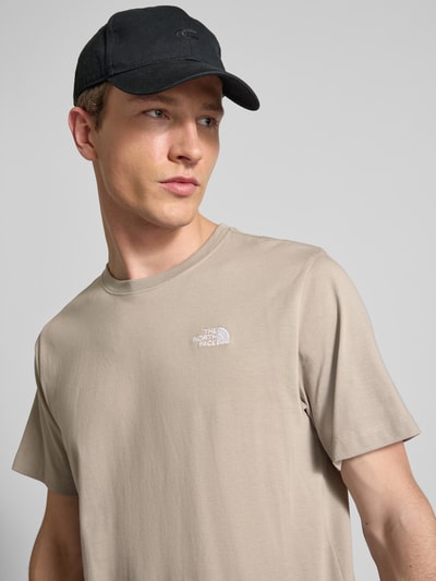 Męski model nosi T-shirt mit Label-Stitching od The North Face, mieszanka bawełny, krój regular fit, okrągły dekolt, długość tyłu 70 cm, zbliżenie górnej części ciała