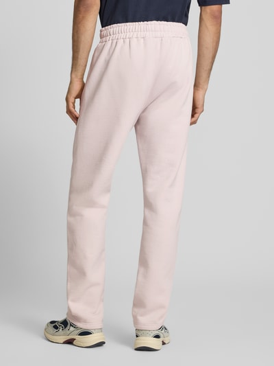 Männermodel trägt Straight Fit Sweatpants mit Logo-Stitching von Pegador aus Baumwoll-Mix mit Bund und Eingrifftaschen, Ganzkörperansicht Rückansicht.
