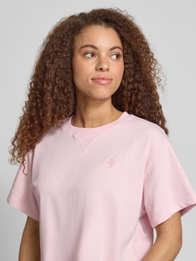 Frauenmodel trägt kurzärmeliges Sweatshirt mit Stickerei von REVIEW in zartem Rosa, relaxed Fit, Baumwoll-Mix, Nahaufnahme Oberkörper.