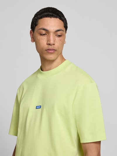 Männermodel trägt Regular Fit T-Shirt aus reiner Baumwolle Modell 'NIEROS' von Hugo Blue in Optik: Unifarben mit Logo-Detail, Kurzarm, Rundhals, Nahaufnahme Oberkörper.