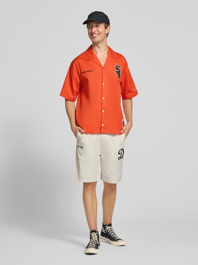 Männermodel trägt Relaxed Fit Shorts aus reiner Baumwolle von Champion in Beige mit Logo-Stitching, elastischem Bund und Tunnelzug, Ganzkörperansicht von vorne.