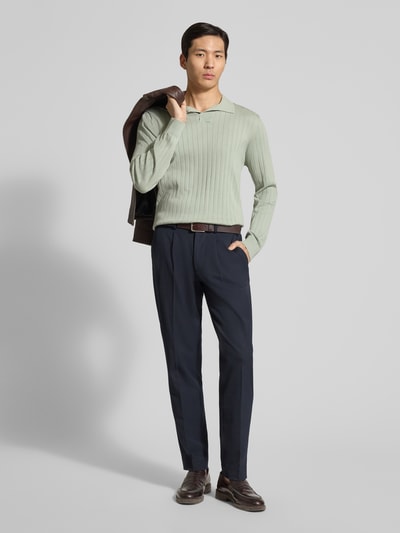 Męski model nosi Loose Fit Poloshirt aus reiner Baumwolle Modell 'TORINO' od SELECTED HOMME w kolorze jasnej zieleni, struktura prążkowana, długi rękaw z V-dekoltem, patch z logo, pełny widok z przodu