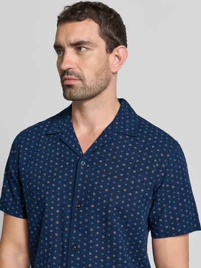 Männermodel trägt Regular fit vrijetijdsoverhemd van katoen en linnen model 'SUMMER' van JACK & JONES premium, mix van katoen en linnen, Reverskraag, all-over look, ruglengte maat M 72 cm, schouderbreedte 48 cm, mouwlengte 23 cm, donkerblauw met fijn patroon, nahaufnahme bovenlichaam.