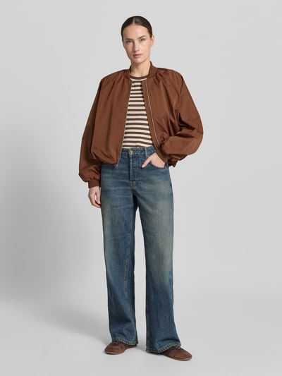 Frauenmodel trägt Blouson mit elastischen Ärmelabschlüssen und Reißverschluss von Zero in Braun, Loose-Fit, Stehkragen, Raglanärmel; Rückenlänge 52 cm, Schulterbreite 40 cm, Brustweite 50 cm, Ärmellänge 55 cm, Jeans und gestreiftes Shirt, Ganzkörperansicht von vorne.