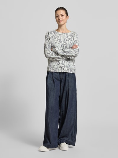 Frauenmodel trägt Comfort Fit Sweatshirt aus Baumwoll-Mix von Tom Tailor Denim mit abstraktem Allover-Muster und Logo-Applikation, Grautöne, Rundhals, Raglanärmel, kombiniert mit weiter Hose, Ganzkörperansicht von vorne.