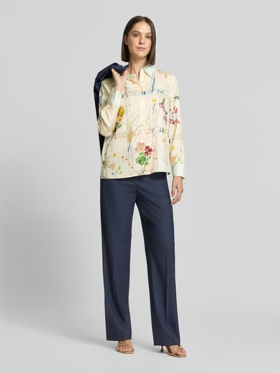 Vrouwenmodel draagt Regular fit overhemdblouse uit zuiver zijde van HERZENS met all-over bloemenprint, overhemdkraag, met lange mouwen, ruglengte maat 36: 66 cm, mouwlengte maat 36: 64 cm, vooraanzicht hele lichaam.