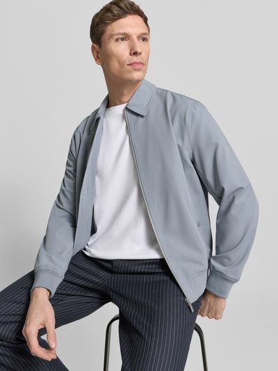Męski model nosi Blouson mit Kentkragen od JAKE*S STUDIO MEN, krój regular fit, jasnoszary, gładka tekstura, widok na całą sylwetkę z przodu. Długość tyłu w rozmiarze M: 60 cm, szerokość ramion w rozmiarze M: 48 cm, szerokość klatki piersiowej w rozmiarze M: 58 cm, długość rękawa w rozmiarze M: 67 cm.