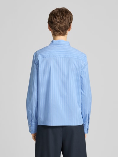 Vrouwenmodel draagt Slim Fit Schluppenbluse met Knopfleiste van Stefanel in lichtblauw met witte strepen, katoenmix met stretch, opstaande kraag, ruglengte 60 cm, mouwlengte 62 cm, slim fit, geheel zichtbare rug, volledige lichaamsweergave achteraan.