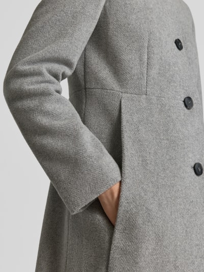 Frauenmodel trägt Regular Fit Mantel aus Woll-Mix von FUCHS SCHMITT in Hellgrau mit Knopfleiste und Stehkragen, Nahaufnahme Oberkörper. Rückenlänge 84 cm, Schulterbreite 41 cm, Brustweite 47 cm, Ärmellänge 67 cm.