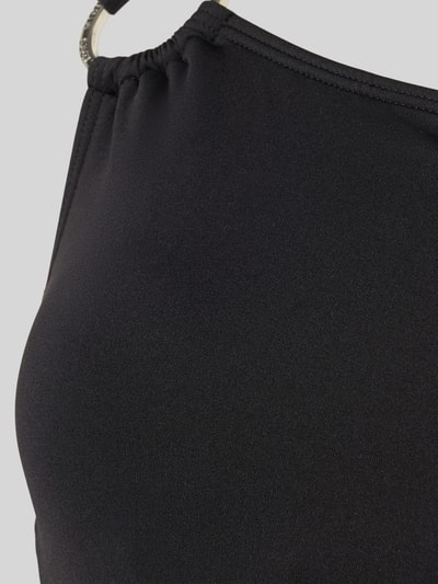 Frauenmodel trägt Badeanzug im One-Shoulder-Look von Michael Kors aus schwarzem Material-Mix mit Stretch-Anteil, Raffungen, Nahaufnahme Oberkörper.
