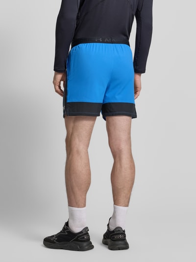 Männermodel trägt Regular Fit Shorts mit Logo-Detail von Under Armour, Modell 'Vanish Graphic', blauwe kleur, elastische logoband, detailopname achterkant.