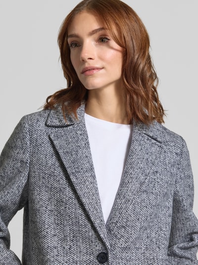 Modelka kobieca nosi Regular Fit Mantel mit Reverskragen od Tom Tailor, melanż, krój regular fit, kołnierz z połami, zapięcie na listwę guzikową, rękawy długie, kieszenie z patką, wykończenie materiału Bouclé, zbliżenie na górną część ciała