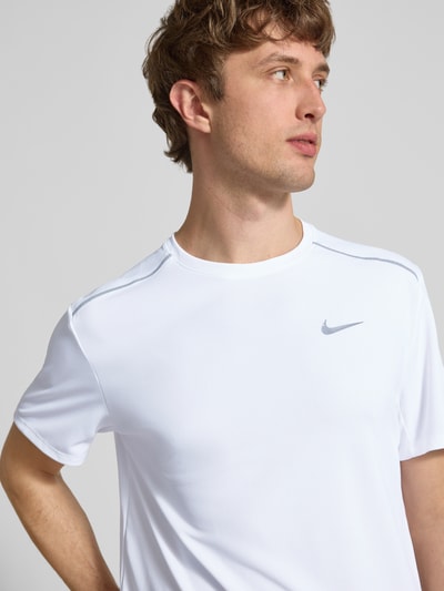 Männermodel trägt T-Shirt mit Rundhalsausschnitt und Logo von NIKE TRAINING in Weiß mit Kontraststreifen, Regular-Fit, Nahaufnahme Oberkörper. Rückenlänge bei Größe M: 74 cm.