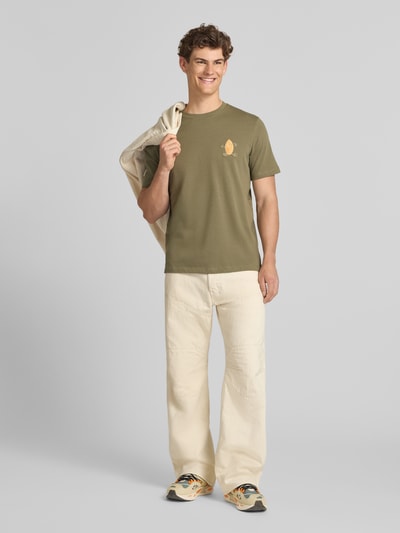 Männermodel trägt Herren T-Shirt mit Stitching Modell 'SUN ISLAND' von Blend in Olive, Reine Baumwolle, Regular-Fit, Ganzkörperansicht von vorne.
