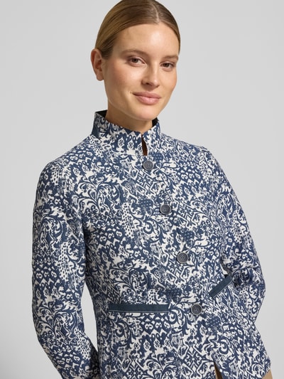 Modelka nosi Slim Fit Blazer im Allover-Look mit Stehkragen od WHITE LABEL, mieszanka bawełny, wzór na całej powierzchni, listwa guzikowa, długość tyłu w rozmiarze 36: 62 cm, szerokość w rozmiarze 36: 46 cm, długość rękawów w rozmiarze 36: 63 cm, zbliżenie na górną część ciała z przodu.