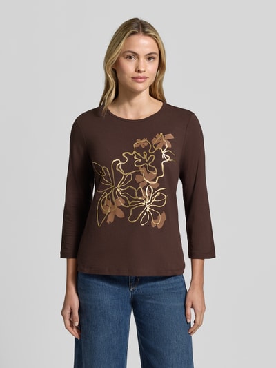 Frauenmodel trägt 3/4-Shirt mit Frontprint von TOM TAILOR, braun, florales Motiv, Regular Fit, 3/4-Arm, glatte Textur, Ganzkörperansicht von vorne.
