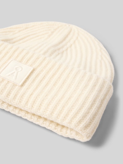 Produktfoto, cremeweiße Mütze aus reiner Wolle Modell 'ICONIC Å WOOL' von ARMEDANGELS, gerippte Struktur auf grauem Hintergrund