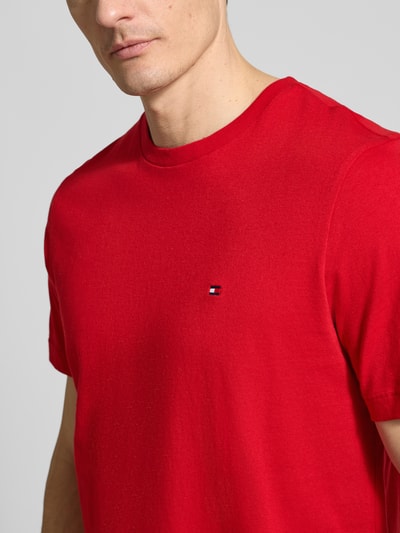 Männermodel trägt Regular Fit T-Shirt aus reiner Baumwolle von Tommy Hilfiger in Optik: Unifarben mit Logo-Stitching, Nahaufnahme Oberkörper