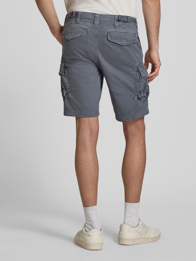 Männermodel trägt gerade geschnittene, graue Straight Fit Shorts mit Cargo-Taschen Modell 'Core' von Superdry, Baumwoll-Mix, Ganzkörperansicht Rückansicht.
