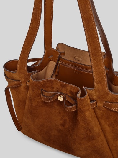 Produktfoto, Tote Bag mit Label-Detail von Tory Burch in Braun mit Hauptfach, Zugband, langen Tragehenkeln, Innenfach mit Reißverschluss, Maße: Breite 40 cm, Länge 29 cm, Tiefe 19 cm, weiche Wildleder-Textur.
