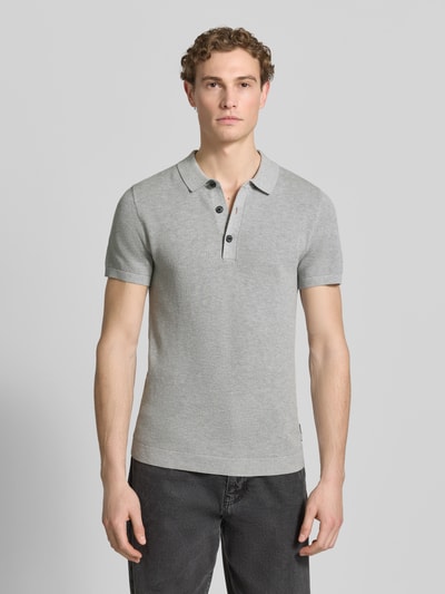 Männermodel trägt Regular Fit Poloshirt aus reiner Baumwolle von s.Oliver RED LABEL, Optik: Unifarben, Strickoptik, Feinstrick, Ganzkörperansicht von vorne.