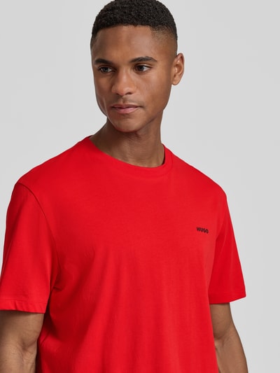 Męski model nosi Regular Fit T-Shirt aus reiner Baumwolle Modell 'DERO222' von HUGO, jednokolorowy, krótki rękaw, okrągły dekolt, jersey, nadruk z logo, krój regular fit, widok na górną część ciała z przodu.