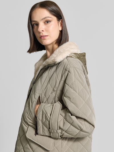 Frauenmodel trägt Steppjacke mit herausnehmbarer Kapuze Modell 'HENRIKE' von Blonde No. 8, beige, Steppmuster, Kunstfell-Innenfutter, Nahaufnahme Oberkörper.